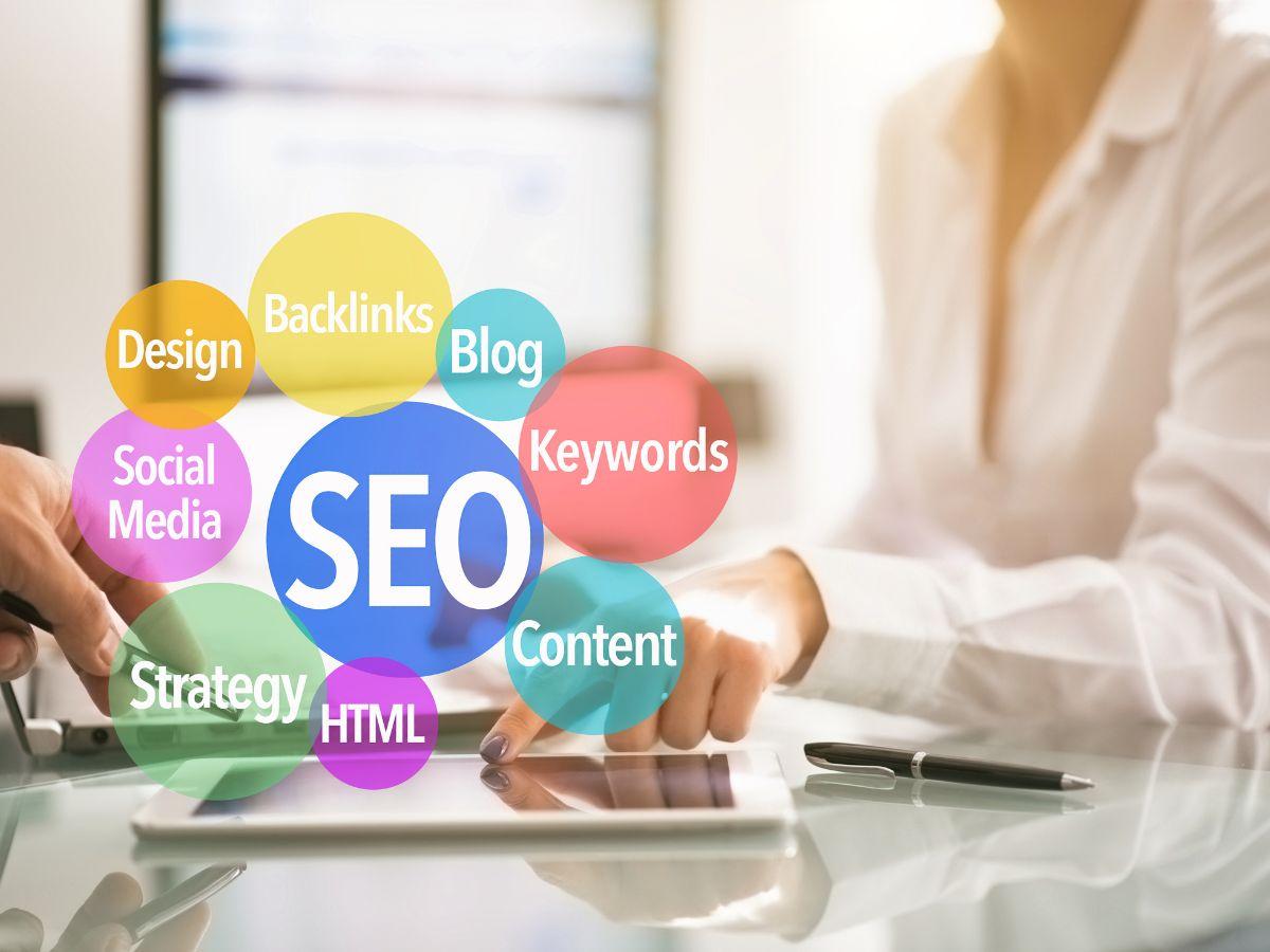 Persona usando una tableta rodeada de conceptos de SEO: palabras clave, contenido, enlaces y estrategia